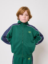 Load image into Gallery viewer, Child wearing a green and navy tracksuit with &#39;B.C.&#39; logo on a white background