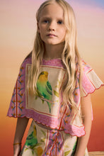 Load image into Gallery viewer, Young girl wearing a colorful dress with bird design against a gradient background