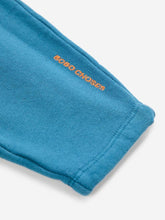 Load image into Gallery viewer, Close-up of a blue fabric with &#39;BOBO CHOSES&#39; branding on a white background