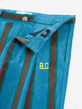 Load image into Gallery viewer, Blue pants with brown stripes and a brand logo on a white background