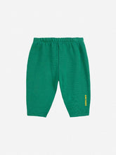Load image into Gallery viewer, Green baby pants with a yellow brand logo on a white background